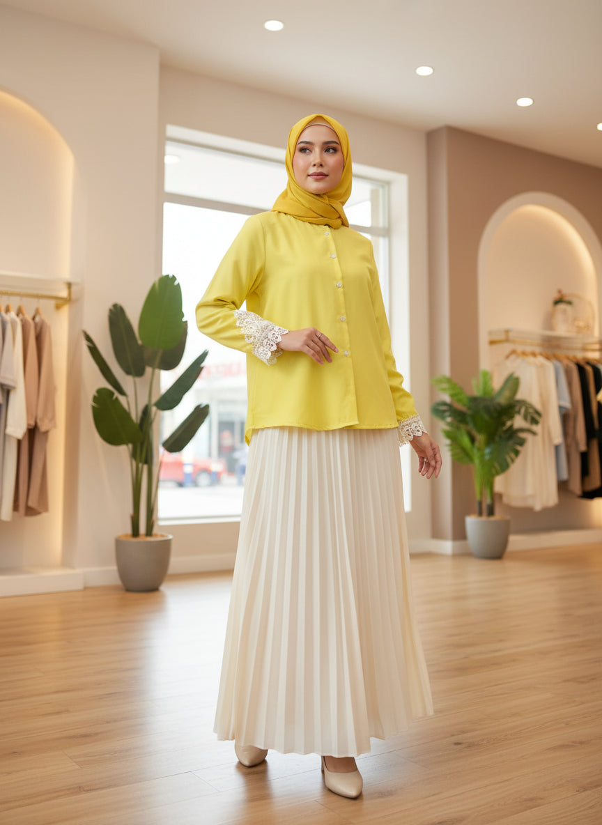 Woman in a yellow top and white skirt standing in a store with plants and clothing racks.